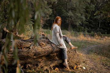 a girl stands in a green forest in spring
