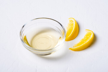 Lemon juice in a bowl. Essence. Lemon slices. White background.
