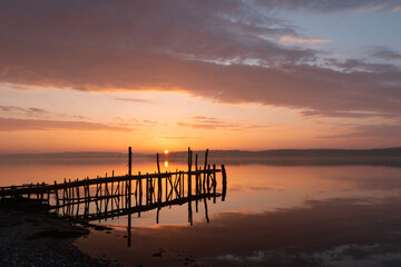 Fototapeta na wymiar Scenic seascape with pier at sunset, burial at sea, condolences 