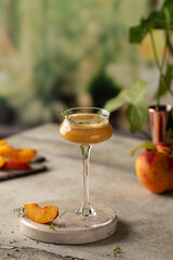 Peach cocktail on marble podium with fresh thyme and juicy peaches.Healthy,detox drink.