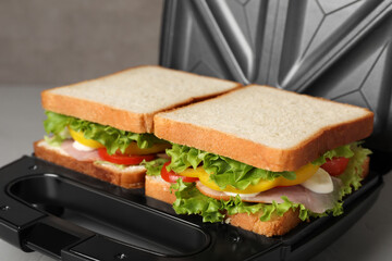Modern grill maker with tasty sandwiches, closeup view
