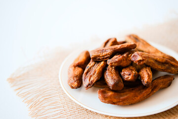 Dried bananas on a light plate. Copy space.