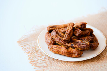 Dried bananas on a light plate. Copy space.