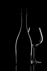 a black bottle and a glass glass on a black background, there is a place for recording