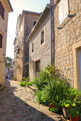 Fototapeta na wymiar Street with old historical buildings in sunny day in Perast, Montenegro