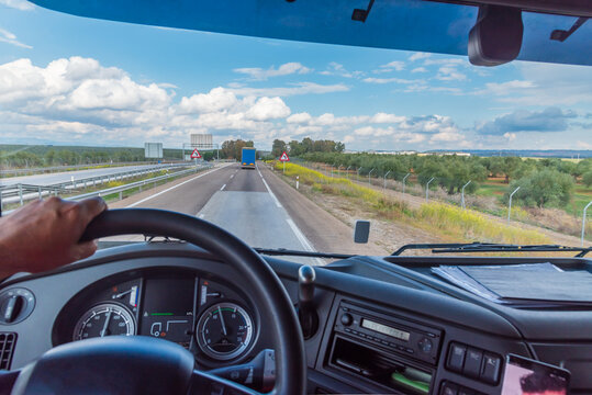 View Of The Road From The Driving Position Of A Truck Of A Landscape With Clouds.