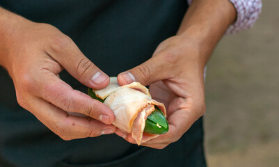 chiles jalape&ntilde;os  rellenos de queso y chorizo envueltos en tocino.

chiles  jalape&ntilde;os 

manos preparando chiles jalape&ntilde;os  en el asador.