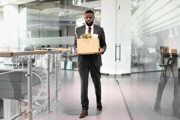 Fototapeta premium Unhappy african american young man employee with working stuff