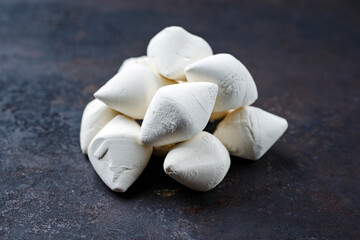 Traditional Afghan dried curd kashk pieces as close-up on black rustic background with copy space