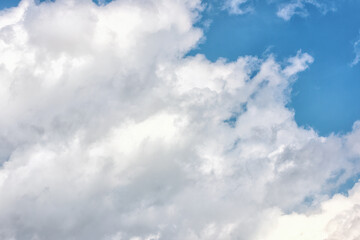 Fluffy white clouds on background of blue sky.