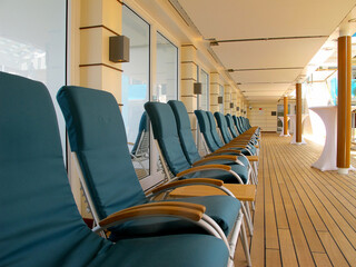 Sun loungers and deck chairs on teak deck terrace or patio or sun pool deck of luxury cruiseship...