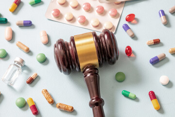 Health and Medicine legal issues. Judge gavel and medication, blue background