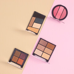 Eye shadows make up products commposition on pastel beige and pink background. Flat lay minimal skin care fashion concept