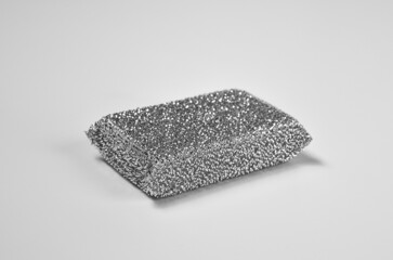 Metallized fiber foam sponge for dishes and housework. New silver foam sponge for dishwashing on a kithen table. Purity and household chores. Front view.