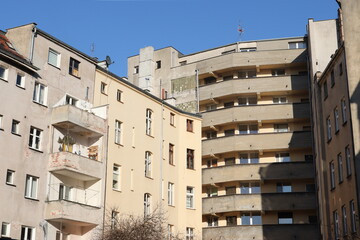 Stare zniszczone budynki we Wrocławiu nadające się do remontu z balkonami w słoneczny dzień.