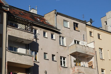 Stare zniszczone budynki we Wrocławiu nadające się do remontu z balkonami w słoneczny dzień. - obrazy, fototapety, plakaty