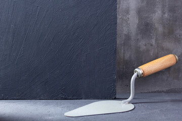 Construction trowel tool on cement  background. Mason tools at concrete wall