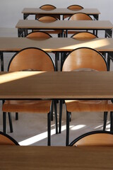 Klasa szkolna z ławkami i krzesłami dla uczniów. 