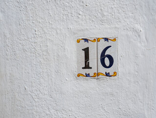 NUMERO 16 EN PARED BLANCA