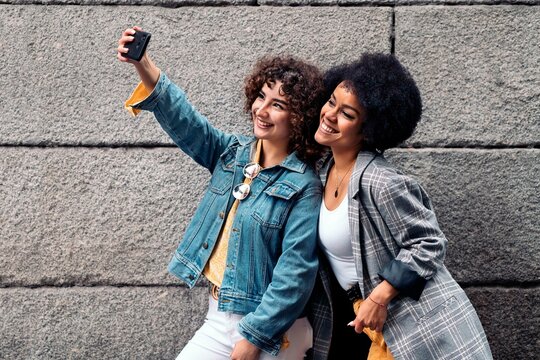 Afro Girl and Friend Taking Selfie