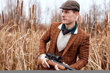 Hunting period, autumn season open. confident caucasian hunter with gun rifle shotgun in hands in...