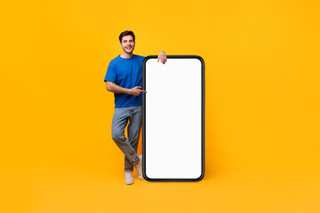 Guy pointing and leaning on big white empty smartphone screen