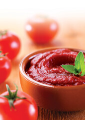 Traditional turkish tomato paste in bowl or spoon with fresh tomatoes on wooden table, homemade healthy food
