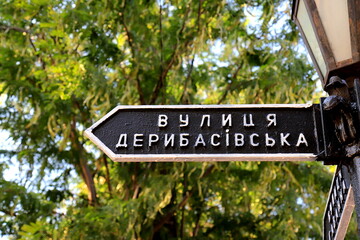 Vintage road sign stands on Deribasovskaya Street in city Odessa, Ukraine. Well-known Deribasivska street is popular from Ukrainian and foreign tourists