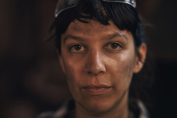 Its not dirt, its my blacksmith badge of honour. Portrait of a confident young woman working at a...