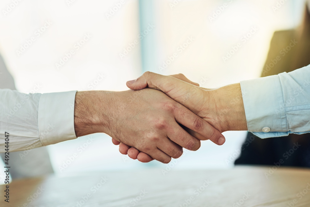 Poster welcome aboard to the best in business. cropped shot of two businessmen shaking hands in a modern of