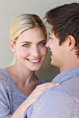 In love with life. Portrait of an affectionate young couple standing against a gray background.