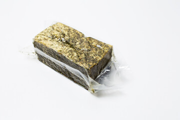Close-up of vacuum sealed smoked tofu isolated on white background.