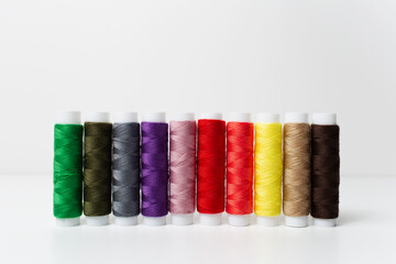 Close-up of colourful thread spools isolated on white background. Studio photo.