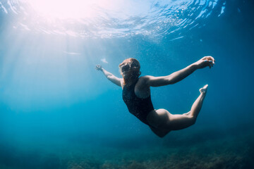 Young woman freediver posing underwater in sea. Freediving and lady