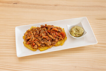 toast made with plantain, with smooth guacamole and shredded meat