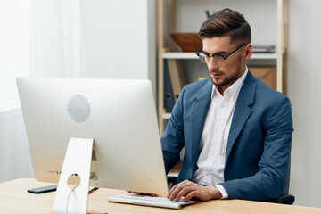 a man in a suit sitting at the computer work boss technologies