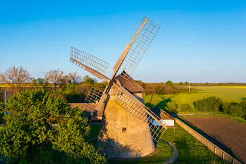 Traditional Hungarian windmill near Hodmezovasarhely. Canola field at the background. Hungarian...