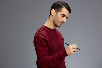 man posing with pen gesture hands red sweater isolated background