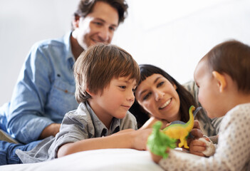 Big brother bonding. Shot of a happy brother and sister playing with their toys while their parents...