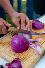 Manos cortando distintas hortalizas para guarnición y ensalada.
col, repollo, cebolla, zanahoria,...