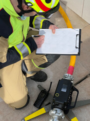 firefighter takes notes of the pressure of the hoses