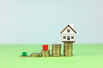 A small wooden house on a stack of coins. What home you get for your money.