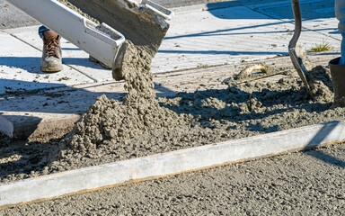 Wet Cement or concrete being poured out of a cement truck onto a construction site forming a...