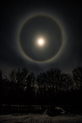 Fototapeta na wymiar Halo around the Moon in the night sky, Ukraine 12.03.2022