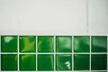 Bright green with white grout retro tile backsplash under aged wood background