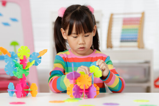 young irl playing creative toy blocks at home