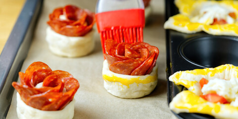 the chef oiling a puff pastry appetizers before baking in the oven. close up