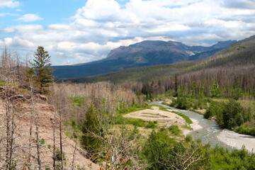view over a valley with river flowing through it, mountains in background