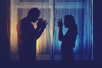 Silhouette of quarreling man and woman at the night window. Married couple husband and wife, violence in evening light of home living room - obrazy, fototapety, plakaty