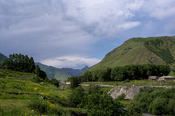 a beautiful fabulous mountain trail with a fence along the edge, where in the distance you can see the clan village.